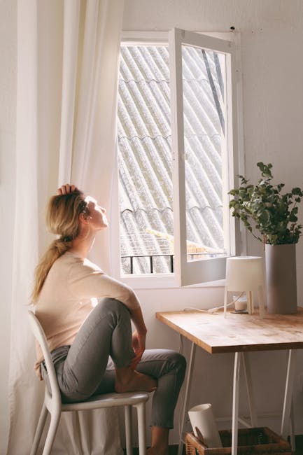 Woman meditating peacefully with a calm expression in a bright room